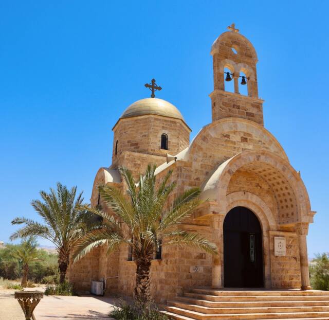an old church with a palm tree in front of it