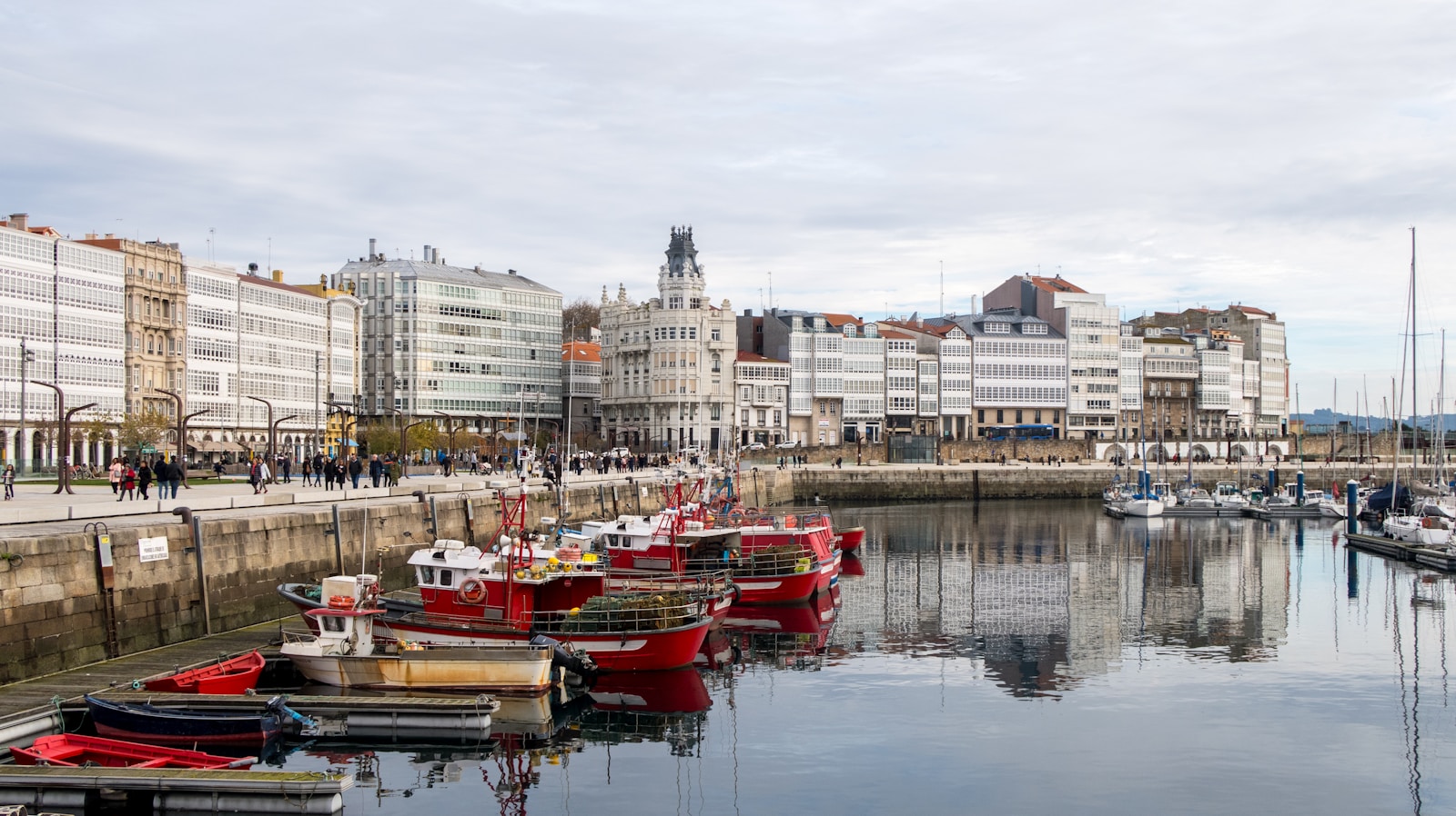 A harbor filled with lots of boats next to tall buildings