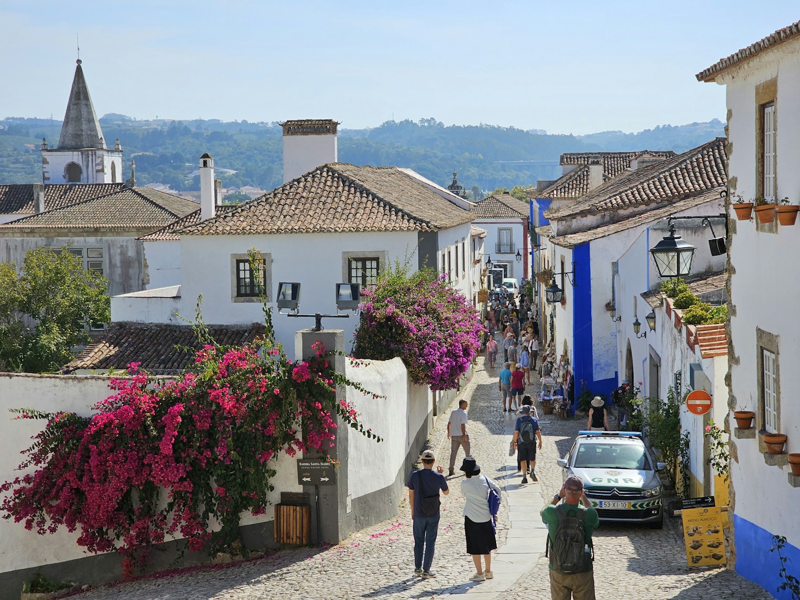 a group of people walking down a cobblestone street
