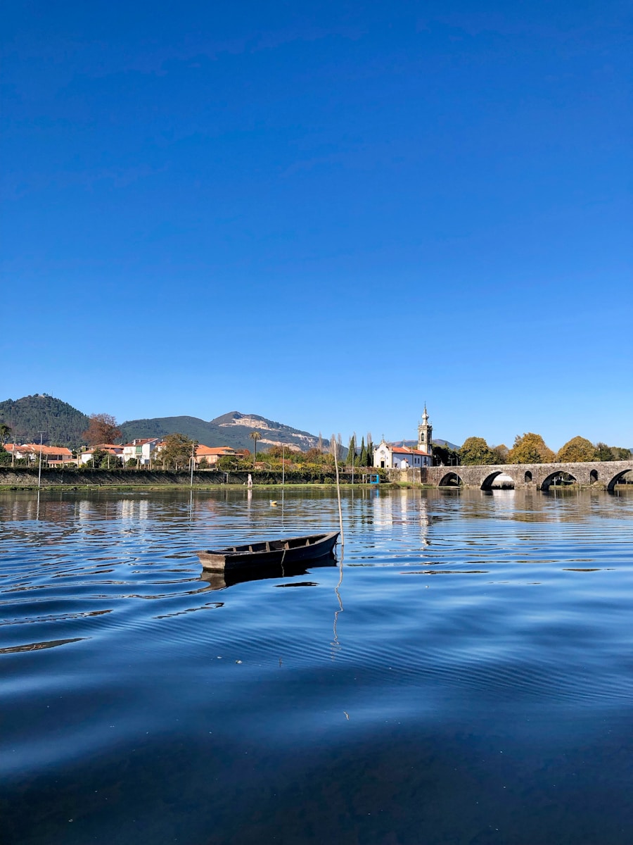 a boat floating on top of a lake next to a bridge